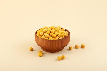 Roasted Chickpea or Leblebi in wooden bowl on beige background. Turkish snack. Selective focus, copy space