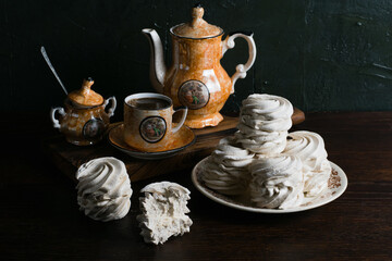Marshmallow and coffee in vintage cup on dark background with copy space on background