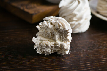 Slice of delicious marshmallow close-up on a dark wooden table