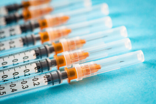 gros plan plusieurs seringues avec aiguille sur fond bleu