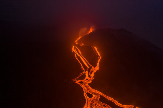Aerial top down view of lava floating down the Volcan Cumbre Vieja at night, a volcano during eruption near El Paraiso town, Las Manchas, La Palma Island, Canary Islands, Spain.