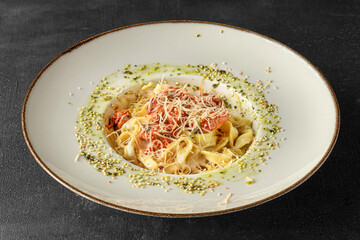 Pasta in a white plate on a black background
