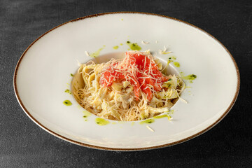 Pasta in a white plate on a black background