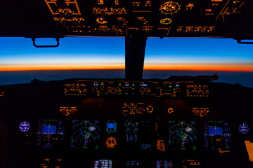Cockpit view of sunset from Boeing 737 over Greenland at 41000 feet.
