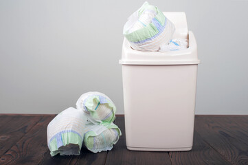 Diapers waste, dirty diapers in garbage pail Disposing of used baby nappies. Environmental Impact...