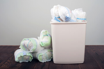 Diapers waste, dirty diapers in garbage pail Disposing of used baby nappies. Environmental Impact...