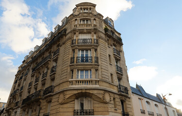 The facade of traditional French house with typical balconies and windows. Paris.