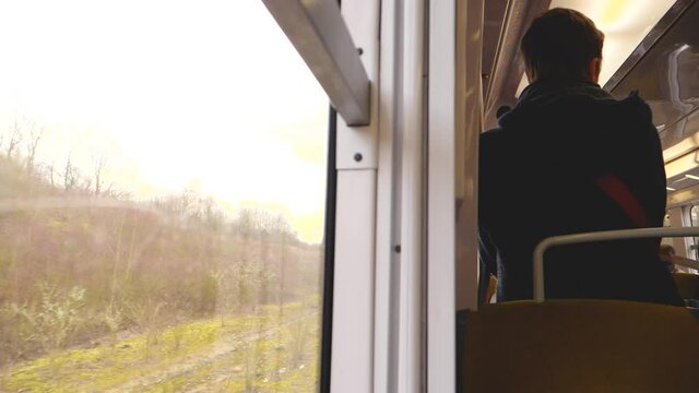 Slow-motion scene rear view of unrecognizable man traveling alone in RER French train 