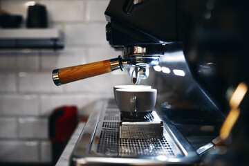 Close up photo of espresso machine working with bar interior background