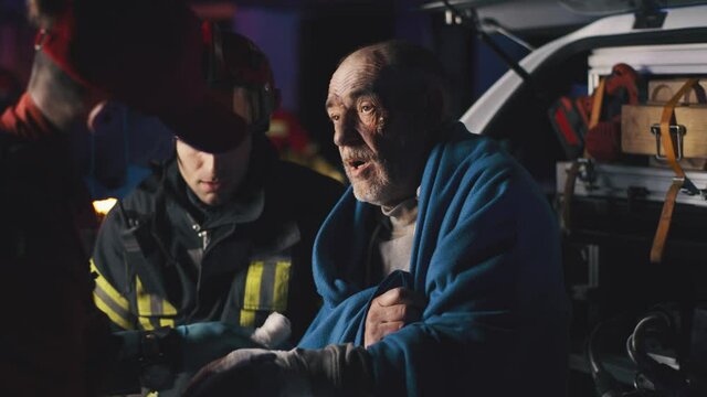Team of EMS Paramedics Bring a Stretcher from Ambulance Vehicle and Help an Injured Young Person. Emergency Care Assistants Arrived on the Scene of a Traffic Accident on a Street at Night.