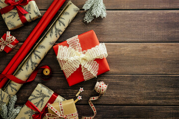 Christmas gift boxes and wrapping paper on rustic wooden table. Flat lay, top view, overhead