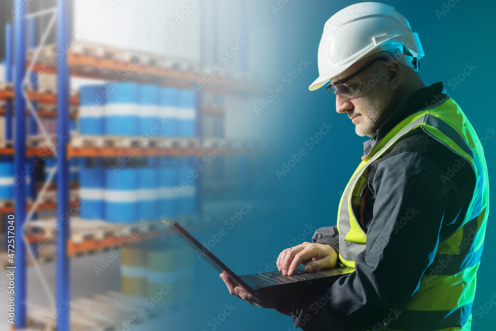 Poster warehouse worker with laptop. logistician works with computer. man in white helmet next to storage r