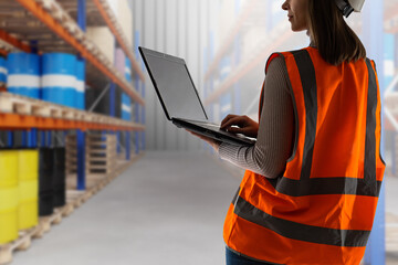Warehouse worker with laptop. Warehouse employee woman. Disabled laptop in hands of girl. Place for...