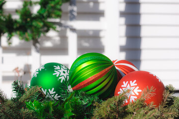 bright red and green christmas ornaments with greenery and white background