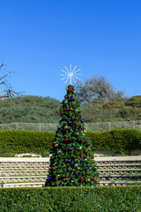 Decorated Christmas tree stands outdoor during day time under blue sky