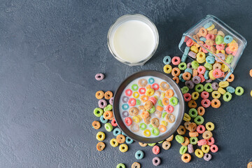 Obraz na płótnie Canvas Crunchy corn flakes rings with milk on dark background
