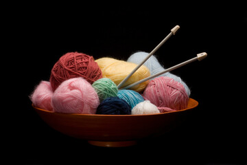 A wooden Bowl with Knitting Yarn and Needles
