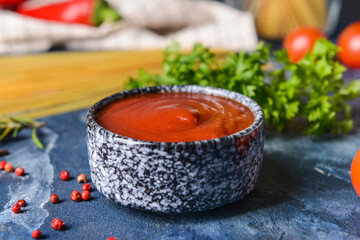 Bowl with organic tomato sauce on color background