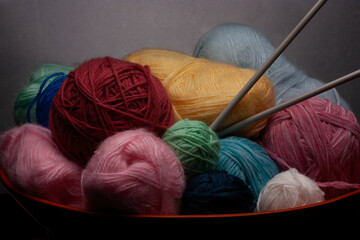 A wooden Bowl with Knitting Yarn and Needles