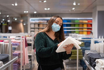 Woman choosing towel in shop