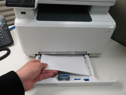 Man loading paper into printer paper tray