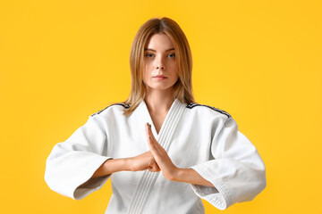 Young woman practicing karate on color background © Pixel-Shot