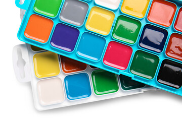 Plastic boxes with watercolor paints on white background