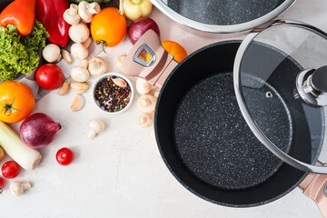 Cooking pot with lid and ingredients for delicious soup on table