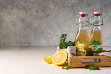 Wooden box with bottles of tasty kombucha on table