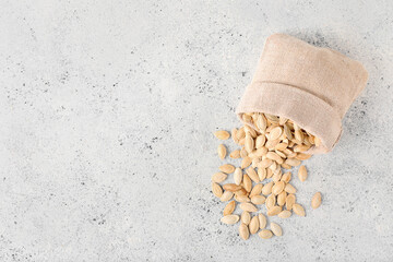 Bag with natural pumpkin seeds on light background © Pixel-Shot