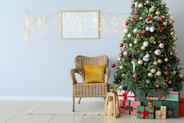 Beautiful Christmas tree, gift boxes, comfortable armchair and blank photo frame on light wall