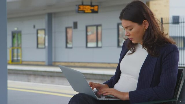 Businesswoman Commuting To Work Waiting For Train On Station Platform Working On Laptop - Shot In Slow Motion