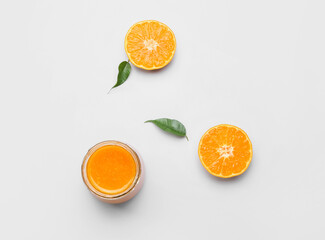 Jar of delicious tangerine jam on white background