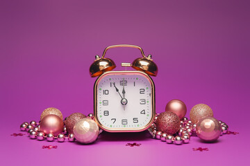 Alarm clock and beautiful Christmas decorations on color background