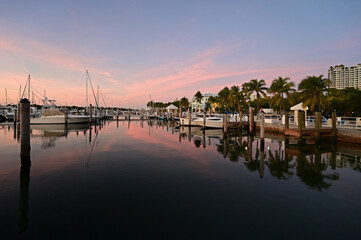 Boats docked in marina in Miami, Florida at sunrise on clear autumn morning.