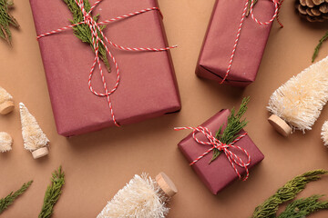 Christmas gifts, coniferous branches and decor on color background, closeup