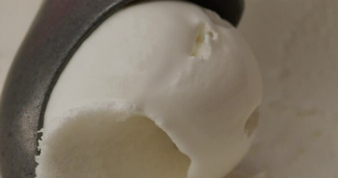 Close up using spoon scooping coconut ice cream.