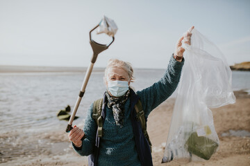 Beach cleanup volunteer carrying garbage bag for environment campaign