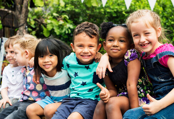 Group of kindergarten kids friends arm around sitting and smiling fun