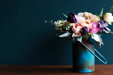 Various fresh flowers arrangement in metalic vase on wooden table - Powered by Adobe