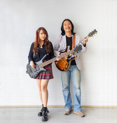 Portrait of Asian family duo rock band of young girl idol on bassist and male on semi hollow...