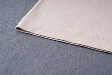 T-shirt sleeves close-up, copyspace, mock up, flat lai, top view. Ready-made T-shirt made of dark gray and beige thick cotton. Background of natural fabrics, texture. Elements of fashion clothing