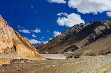 Rocky mountains of Ladakh, fluffy clouds with blue sky, Himalayan mountains in the background, Leh, Jammu and Kashmir, India