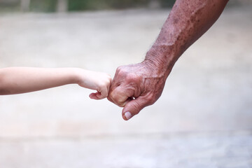 Fist bump between asian grandfather hand and granddaughter hand for familly background