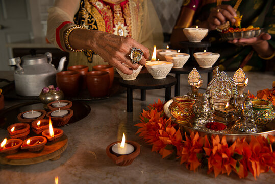 Woman's hand lighting a diya 