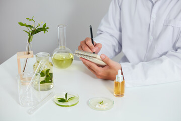 Plants and flowers extract in petri dish and a white background in laboratory , green leaf  in a test tube and scientist for cosmetic advertising , photography science concept