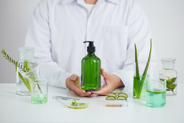 Aloe vera extract in laboratory , petri dish in a white background , green leaf  in a test tube and scientist for cosmetic jar advertising , science concept