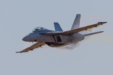 Very close view of a F-18 Hornet approaching in a high G maneuver, with condensation cloud around...