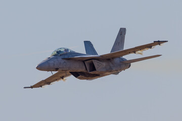 Very close view of a F-18 Hornet approaching in a high G maneuver, with condensation cloud around...