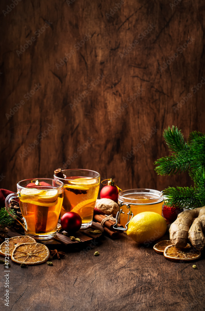 Wall mural winter hot healing tea with ginger, honey, lemon and spices in glass cup with steam, rustic wooden b